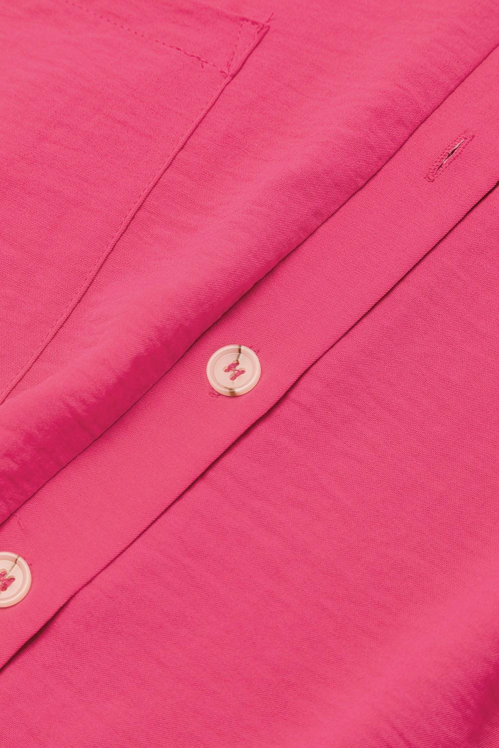 a close up of a pink shirt with buttons