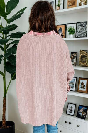 a woman wearing a pink sweater and jeans