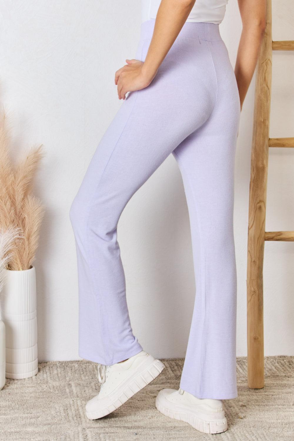 a woman in a white top and purple pants