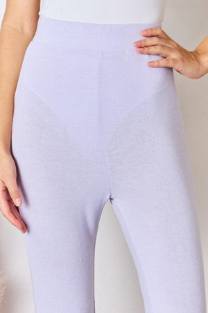 a woman in a white top and purple pants