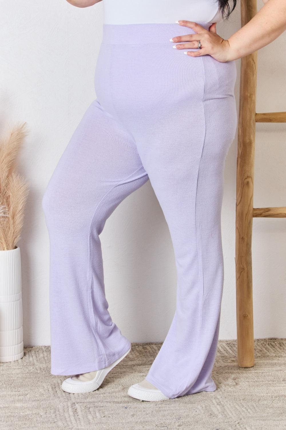 a woman in a white top and purple pants