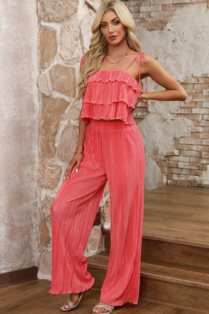 a woman in a pink jumpsuit posing for a picture