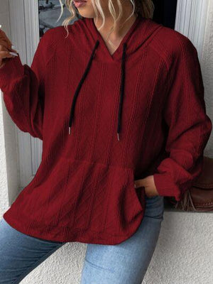 a woman in a red sweater smoking a cigarette