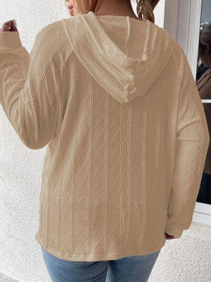 a woman wearing a tan sweater and jeans