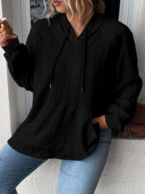 a woman leaning against a wall smoking a cigarette