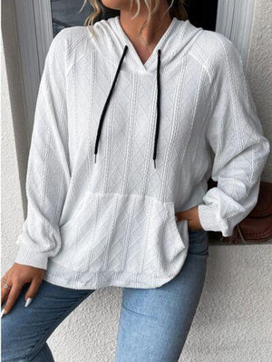 a woman wearing a white sweater and jeans