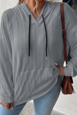 a woman wearing a gray sweater and jeans