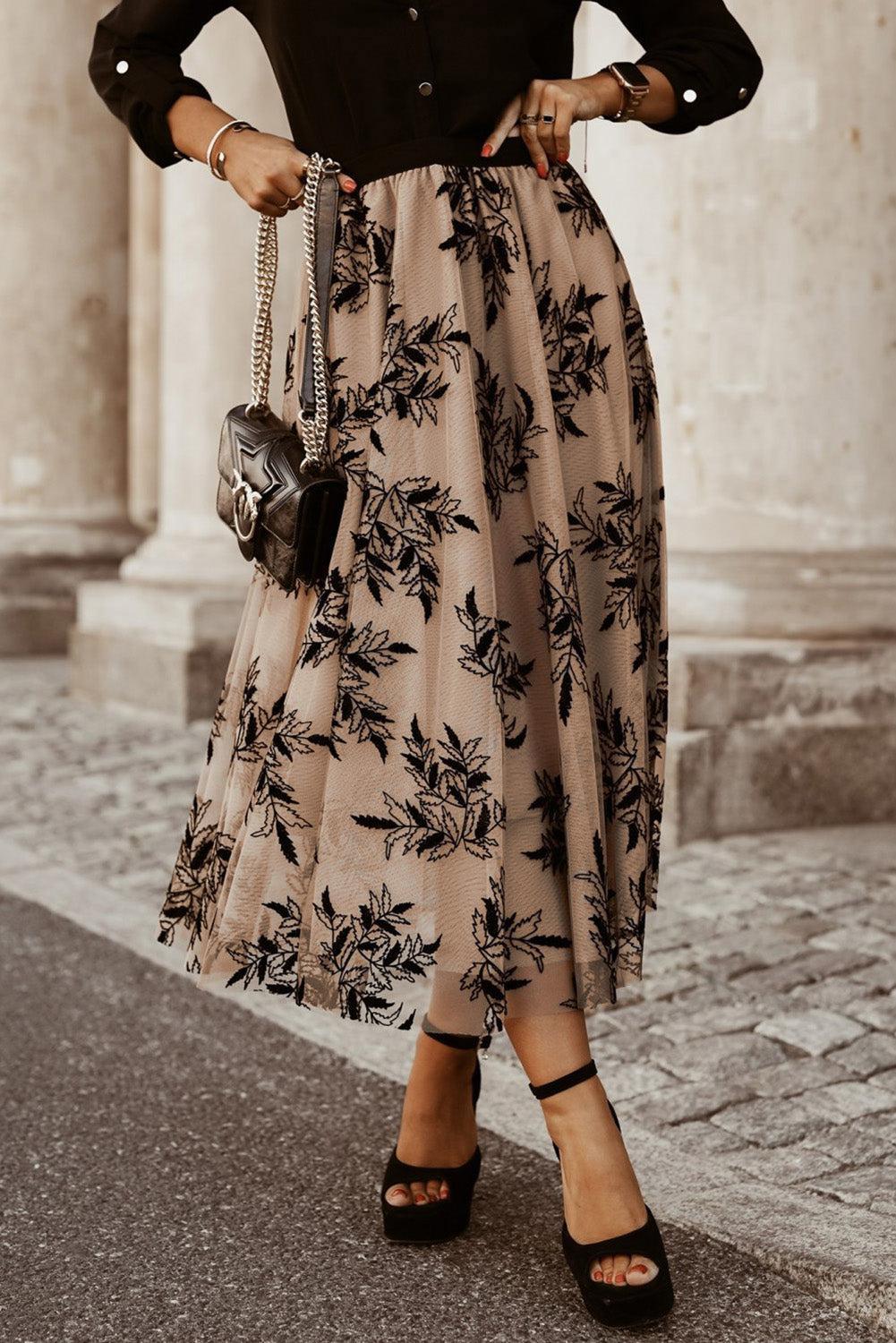 a woman wearing a black shirt and a floral print skirt