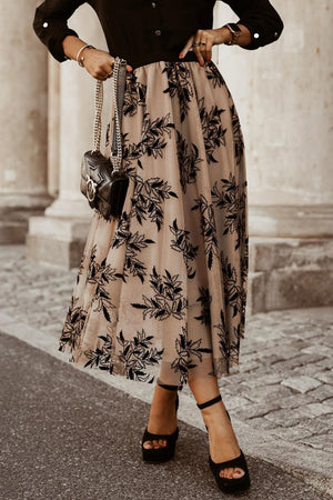 a woman wearing a black shirt and a floral print skirt