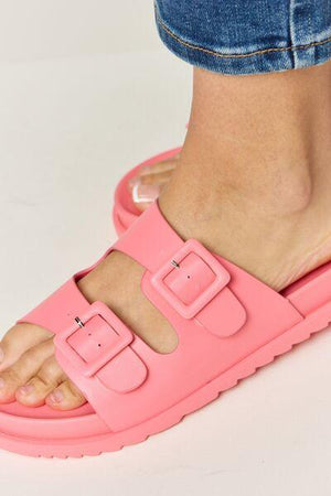 a close up of a person wearing pink sandals