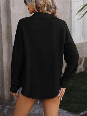 a woman wearing a black sweater and shorts