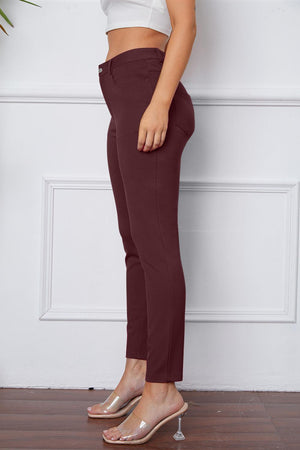 a woman in a white top and maroon pants
