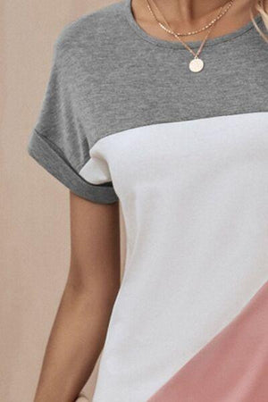 a woman wearing a grey, white, and pink t - shirt