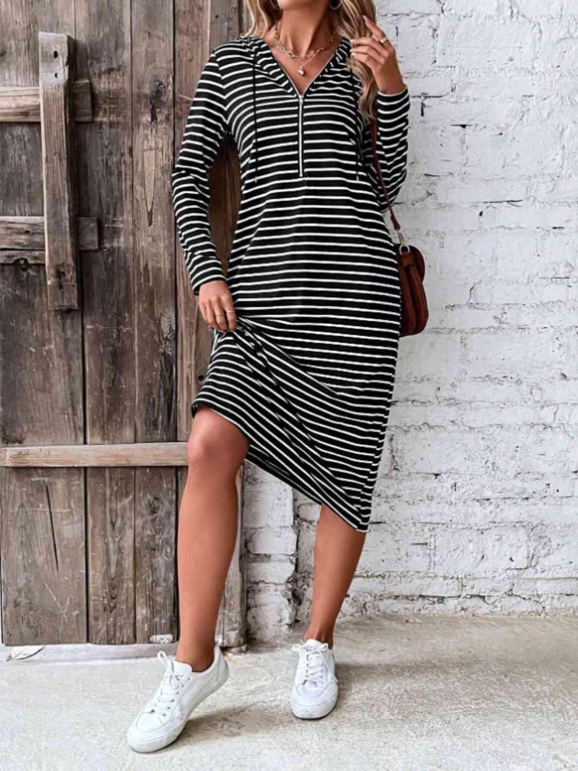 a woman wearing a black and white striped dress