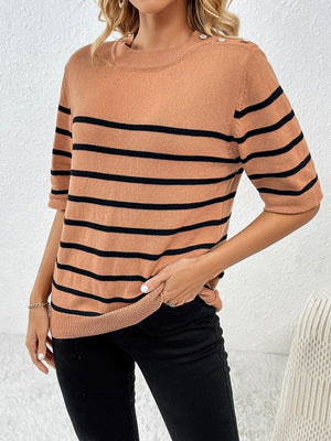 a woman wearing a tan and black striped sweater