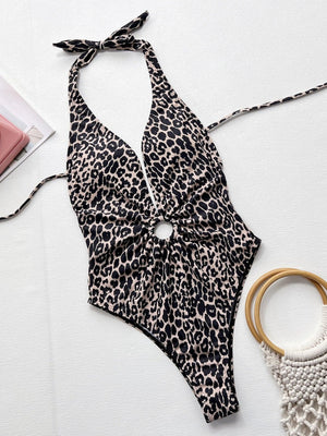 a bathing suit, ring, and bracelet on a white surface