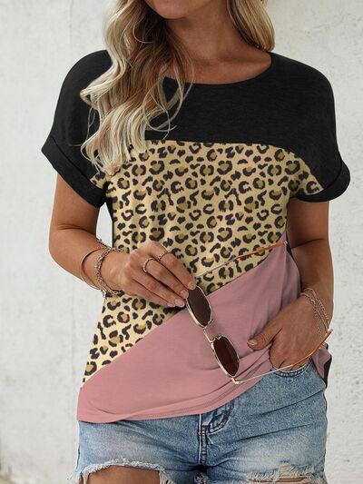 a woman wearing a leopard print shirt and denim shorts