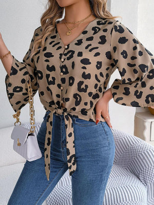 a woman wearing a leopard print shirt and jeans