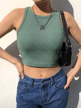 a woman wearing a green crop top and jeans