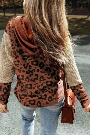 a woman walking down a street wearing a leopard print jacket