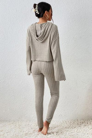 a woman standing on a white rug wearing a sweater and leggings