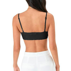 a woman wearing a black bra top and white pants