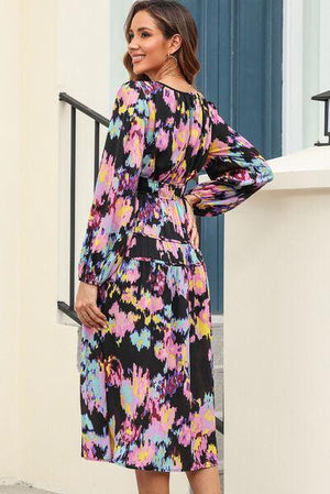 a woman in a colorful dress standing on a balcony