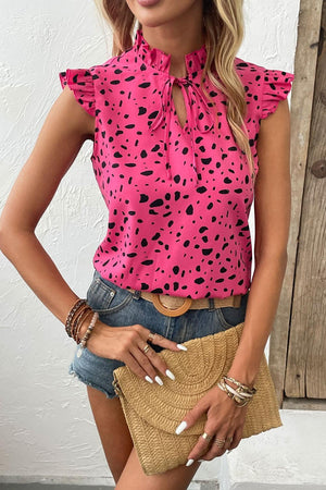 a woman wearing a pink top with black spots