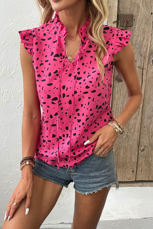 a woman wearing a pink top with black spots