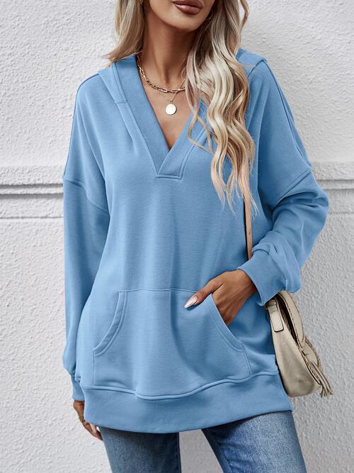 a woman wearing a blue sweatshirt and jeans