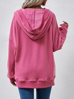 a woman wearing a pink hoodie and jeans