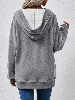 a woman wearing a grey sweatshirt with a white hoodie