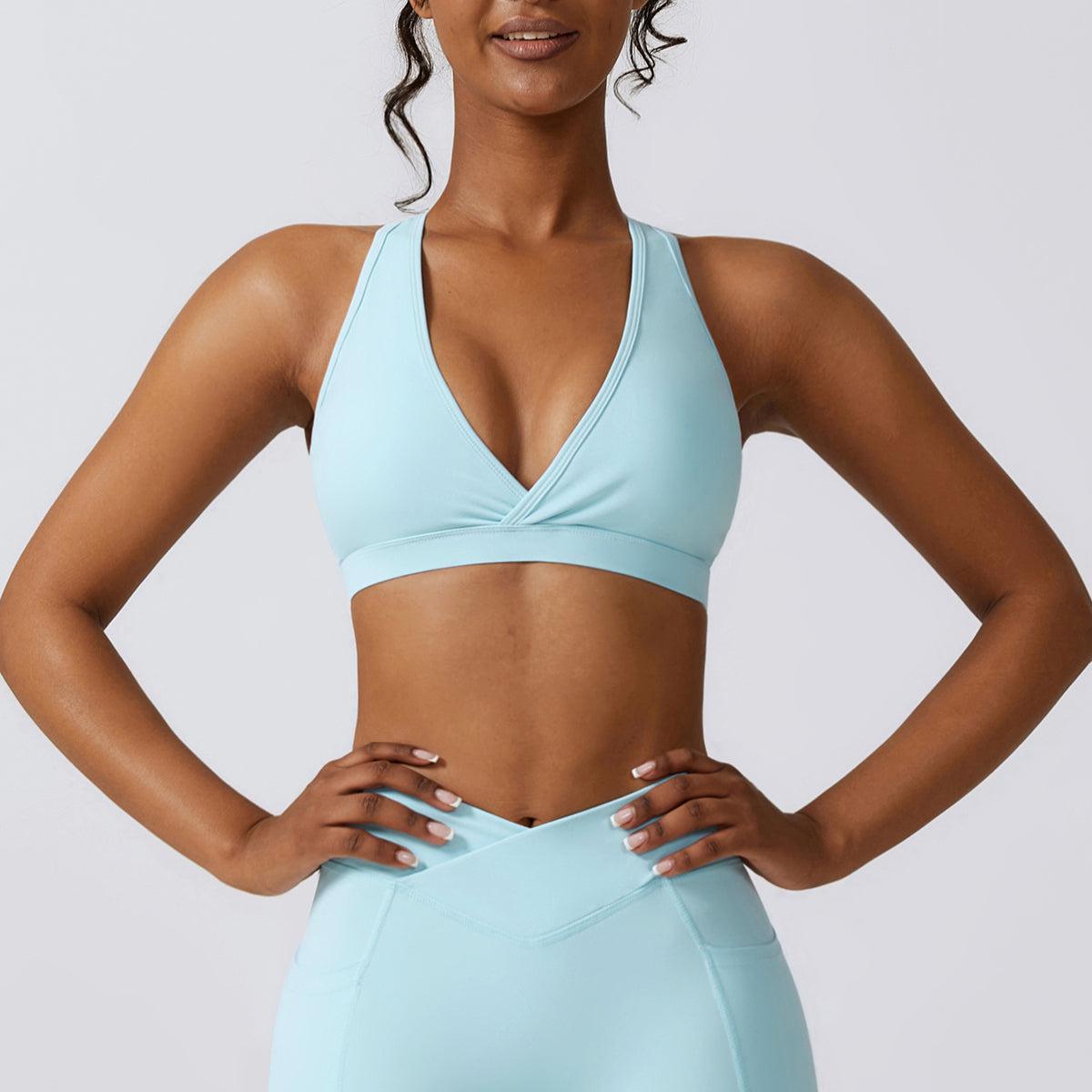 a woman in a light blue sports bra top with her hands on her hips