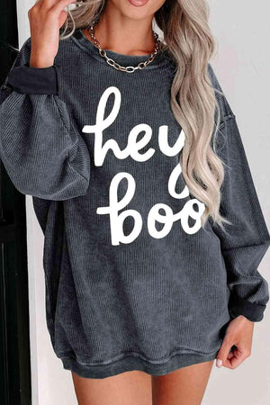 a woman wearing a sweatshirt that says hey boo