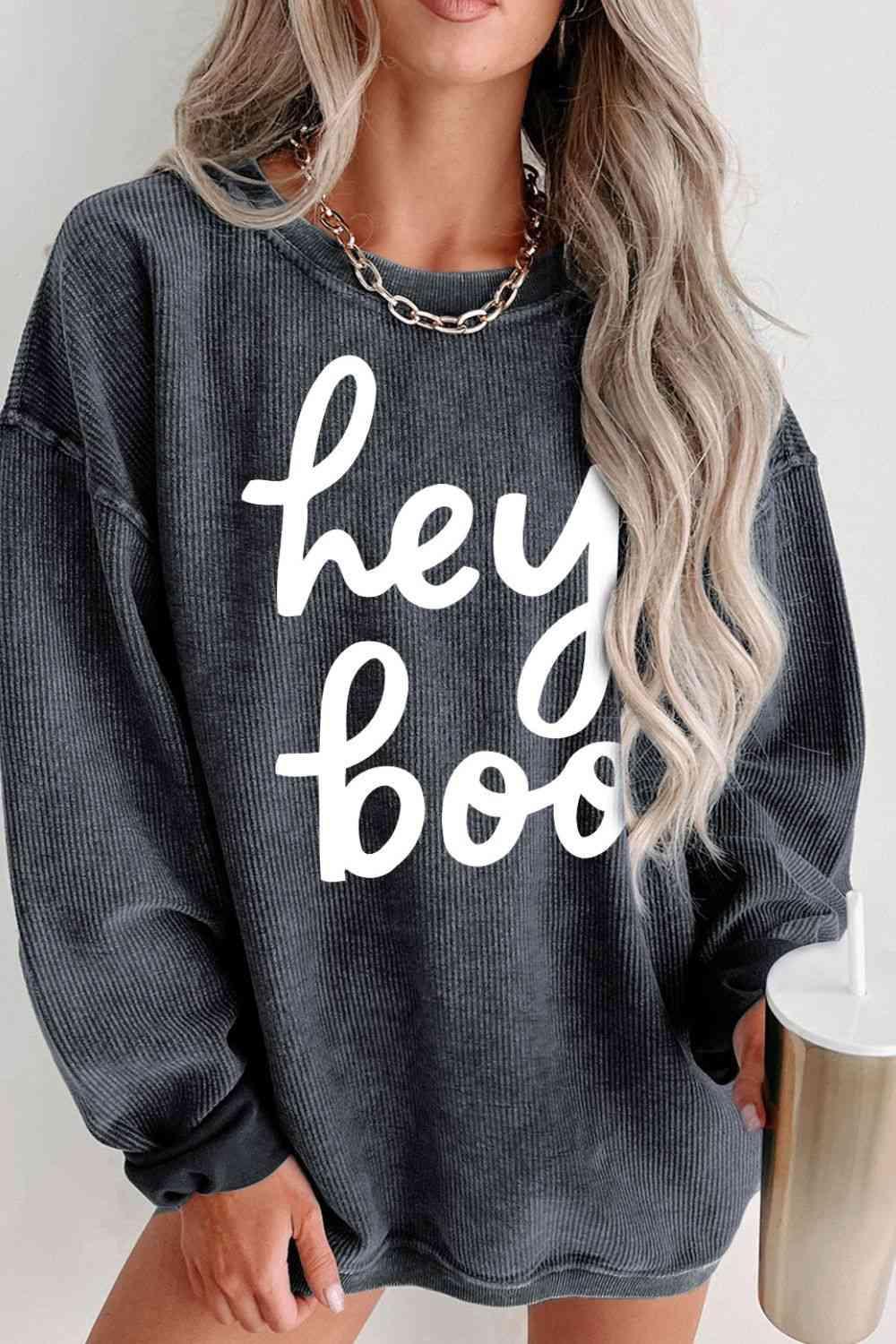 a woman wearing a sweatshirt that says hey boo