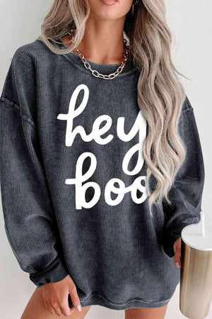 a woman wearing a sweatshirt that says hey boo