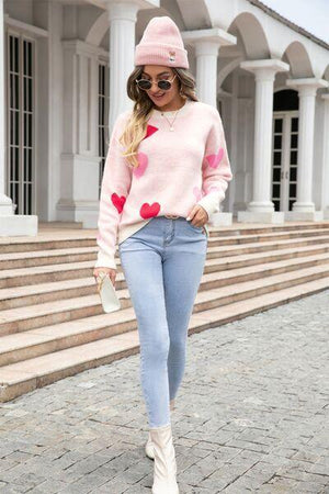 a woman wearing a pink sweater and jeans