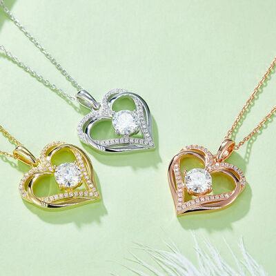 three heart shaped pendants on a green surface