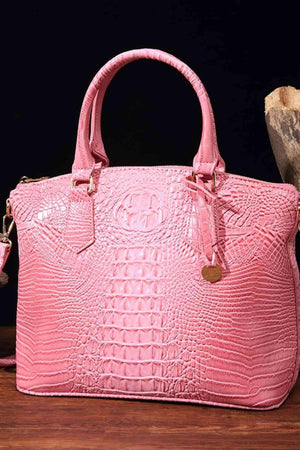a pink purse sitting on top of a wooden table