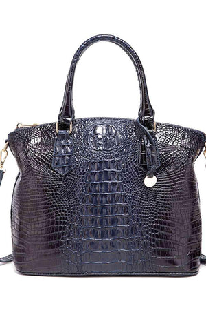 a black crocodile skin handbag with a tassel