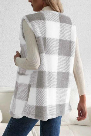 a woman wearing a white and grey plaid sweater