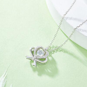 a necklace with a heart and a bow on it