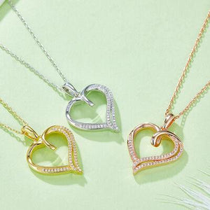 three heart shaped pendants on a green surface