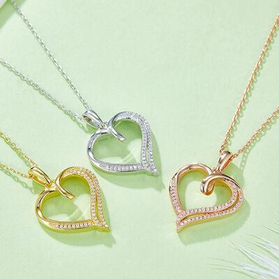 three heart shaped pendants on a green surface