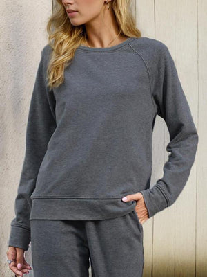 a woman wearing a gray sweatshirt and sweatpants