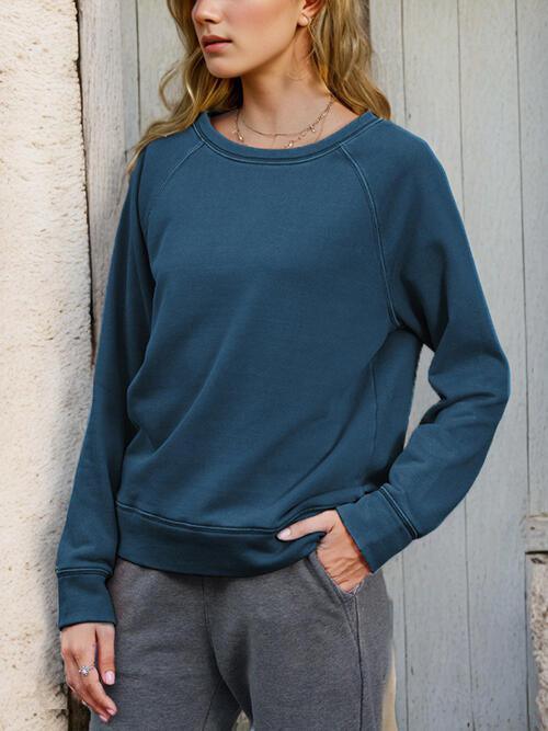 a woman standing next to a wall with her hands on her hips