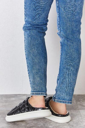 a person wearing black and white shoes and jeans