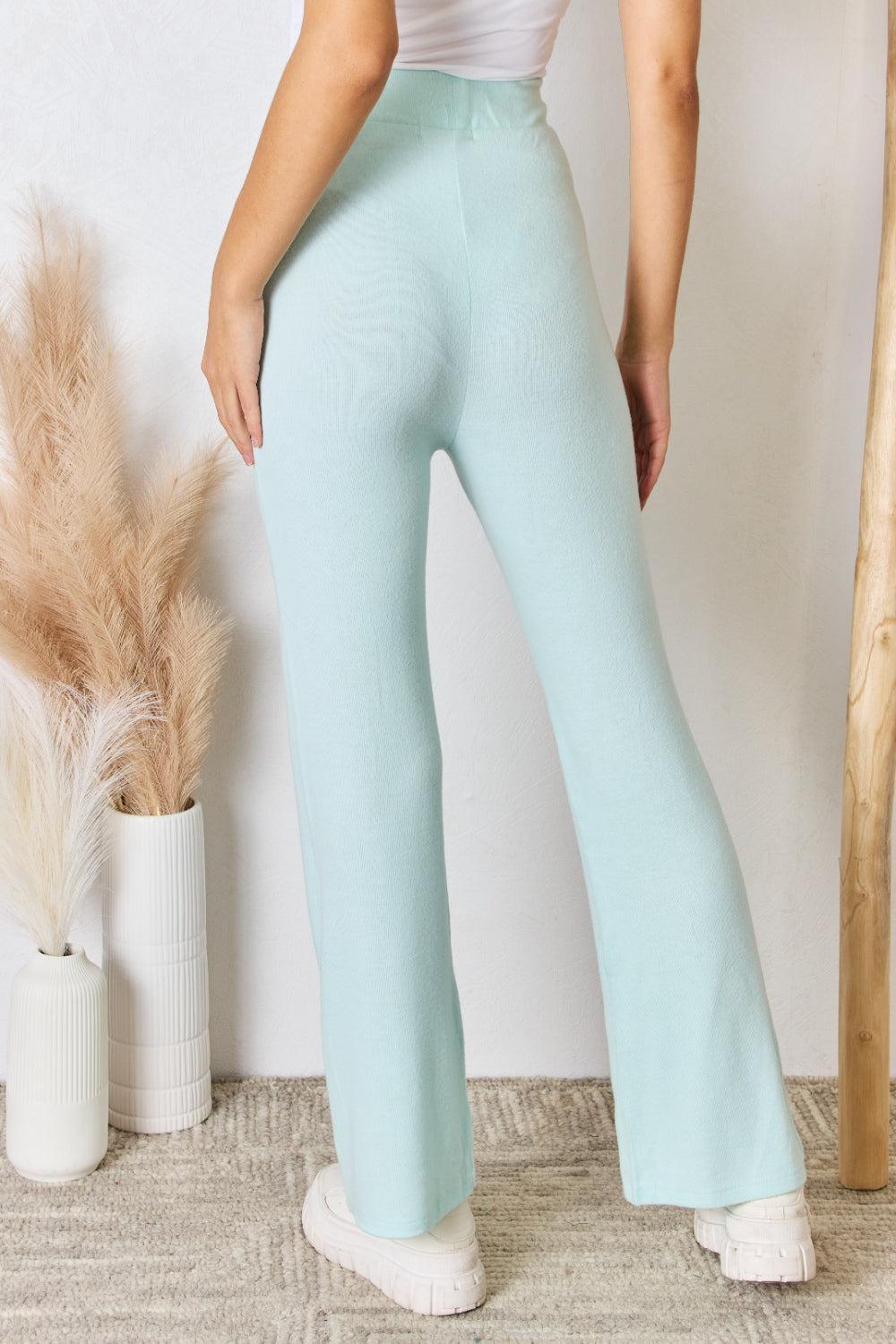 a woman in a white top and light blue pants