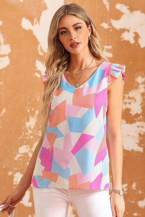 a woman in white pants and a pink and blue top