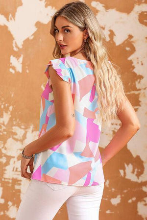 a woman in white pants and a pink and blue top